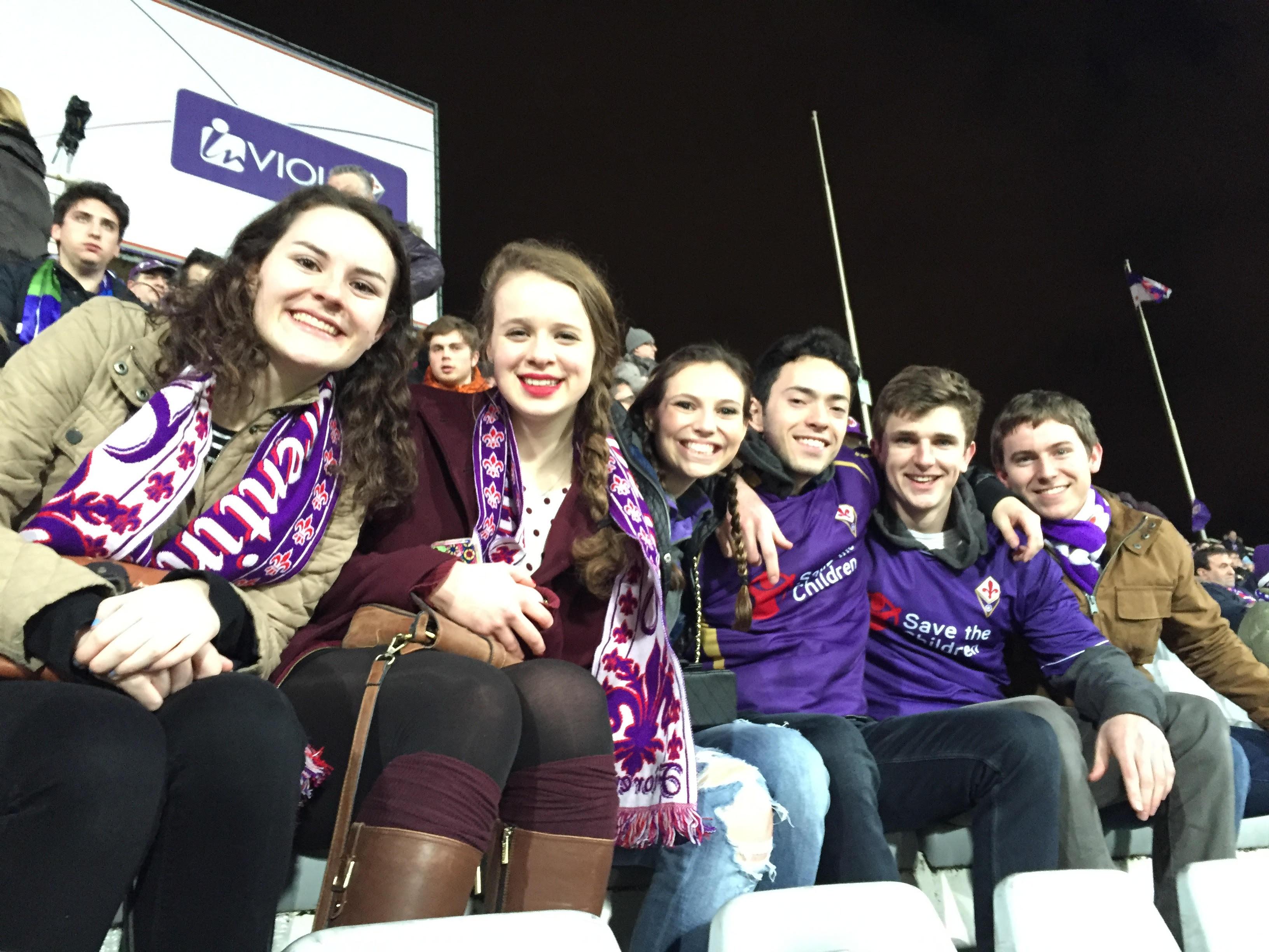 Students wearing AC Fiorentina scarves at a soccer game.