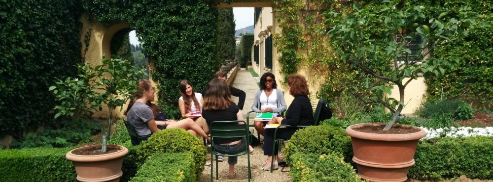 Six students and a professor sitting in the Villa's lemon garden having class.