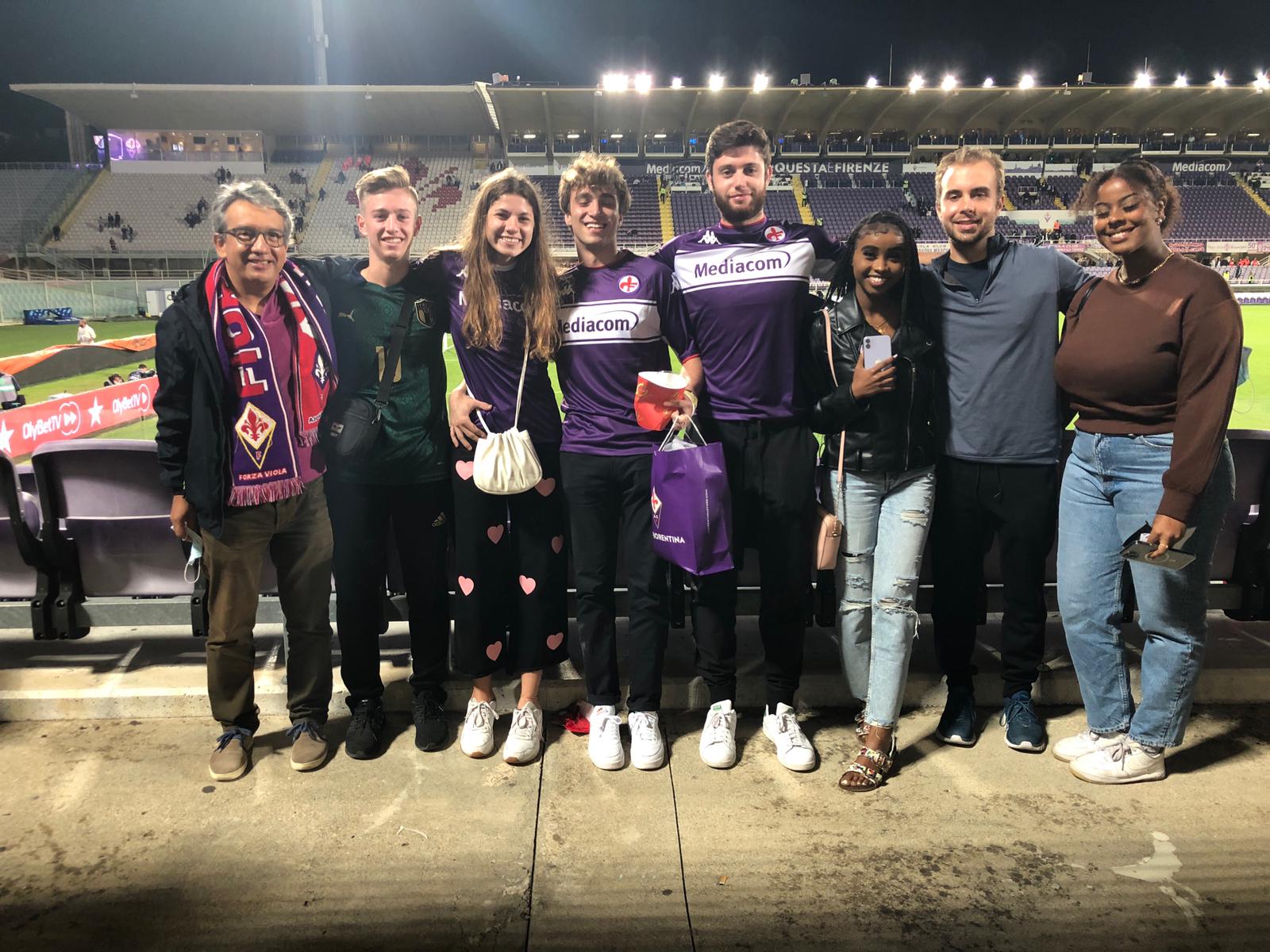 Seven students and the Resident Assistant standing in Florence's soccer stadium.