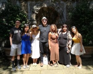 Group of seven School of Continuing Studies students standing in front of the Villa's Triton fountain.