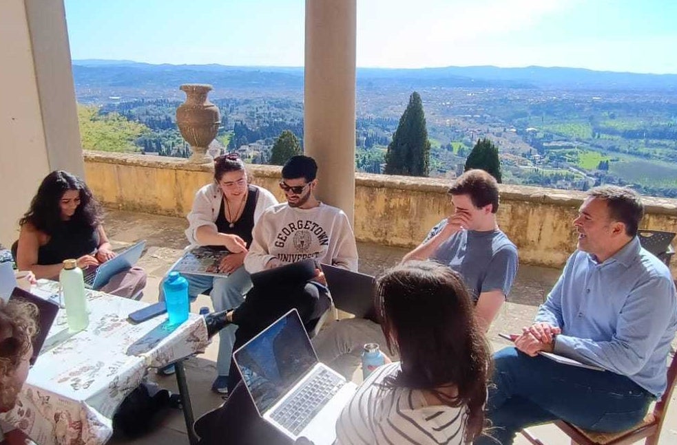 Five undergraduate students and Prof. Mustafa Aksakal sitting with computers around a table on Villa Le Balze's terrace.